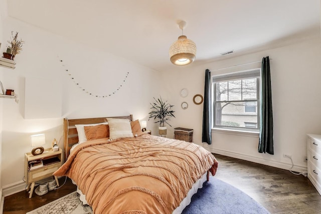 bedroom featuring visible vents, baseboards, and dark wood-type flooring