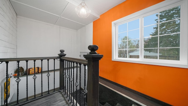 stairway with wood finished floors and a chandelier