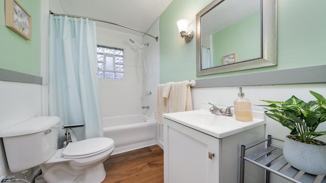 bathroom featuring toilet, shower / tub combo with curtain, vanity, and wood finished floors