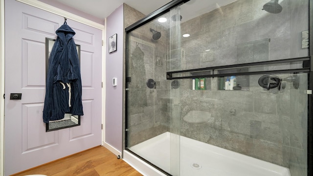 full bath with a shower stall and wood finished floors