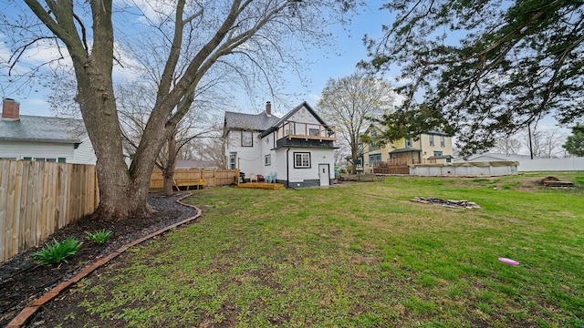 view of yard with a fenced backyard and a balcony