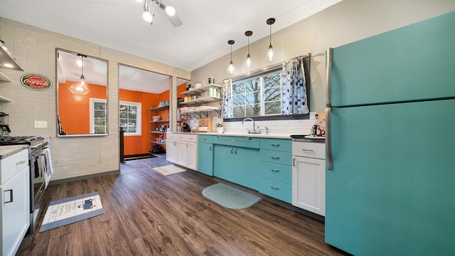 kitchen with open shelves, freestanding refrigerator, a wealth of natural light, and gas range