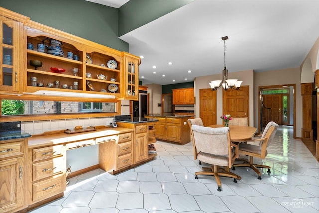 kitchen with a chandelier, dark countertops, tasteful backsplash, glass insert cabinets, and recessed lighting