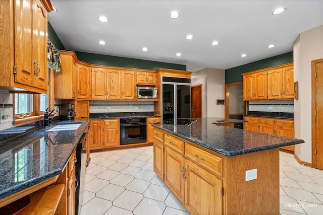 kitchen featuring black appliances, a sink, a kitchen island, recessed lighting, and light tile patterned floors