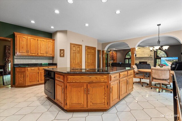 kitchen with black appliances, a kitchen island, arched walkways, decorative backsplash, and recessed lighting