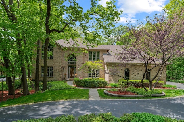 view of front of house featuring brick siding and a front yard
