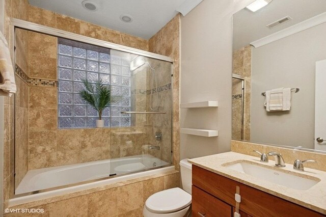 full bathroom with toilet, tiled shower / bath, vanity, and visible vents