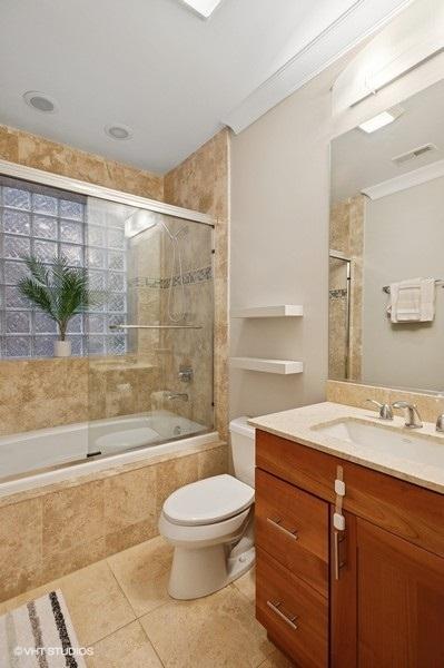 full bath featuring toilet, tiled shower / bath, visible vents, tile patterned floors, and vanity