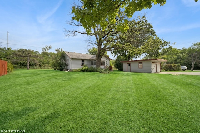 4363 W Kennedy Dr, Gurnee, IL 60031 - view of green lawn with driveway, an outdoor structure, and a garage