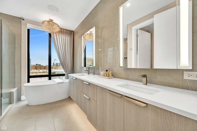 full bathroom featuring a sink, double vanity, decorative backsplash, a freestanding tub, and a view of city