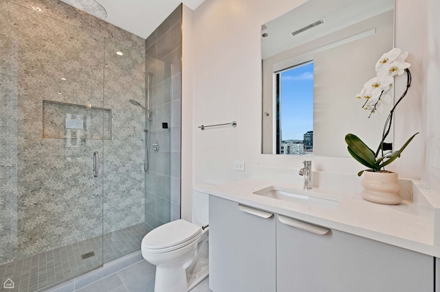 bathroom with a shower stall, toilet, vanity, and visible vents