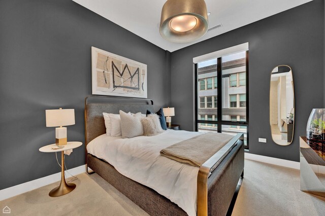 bedroom featuring light colored carpet, baseboards, and visible vents