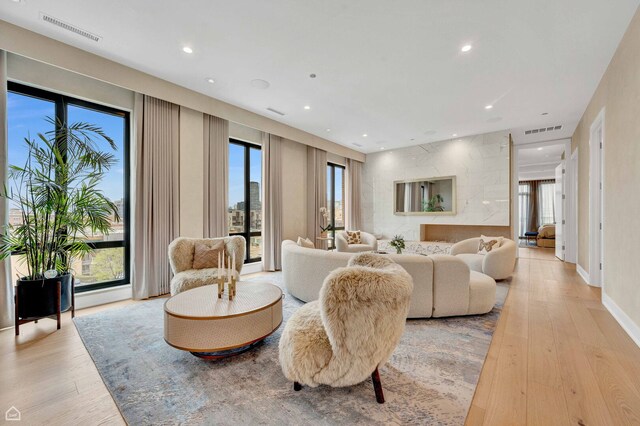 living area with a healthy amount of sunlight, visible vents, and light wood-style flooring