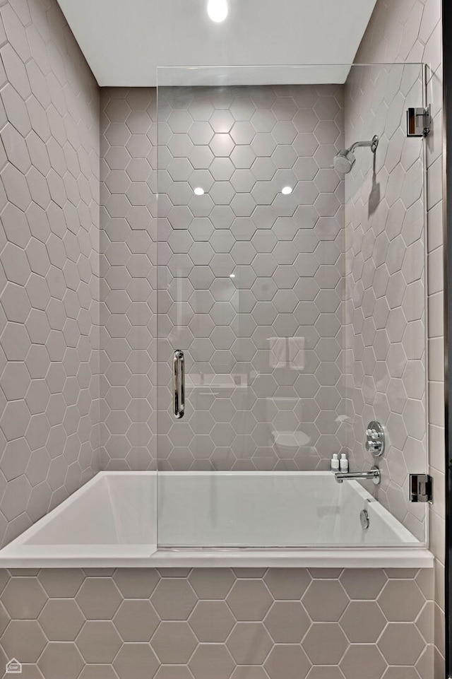 full bathroom featuring a relaxing tiled tub and a tile shower