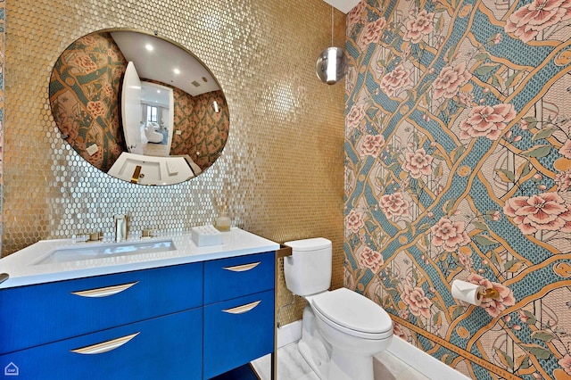 bathroom featuring tile walls, toilet, and vanity
