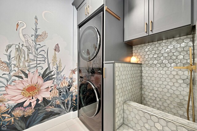 laundry room featuring stacked washer / drying machine and cabinet space