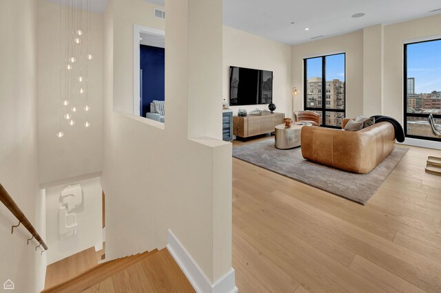 living area featuring recessed lighting, wood finished floors, and visible vents