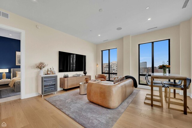 living room featuring light wood finished floors, visible vents, and recessed lighting