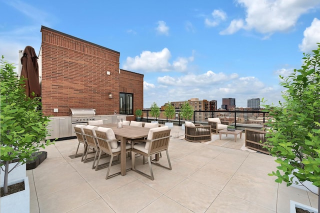 view of patio / terrace featuring a grill, outdoor dining space, and exterior kitchen