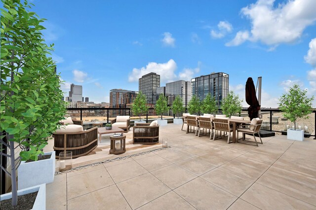 view of patio / terrace featuring a city view, outdoor dining space, and an outdoor hangout area