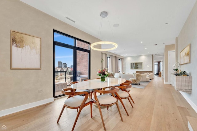 dining space featuring baseboards, light wood-style floors, and visible vents