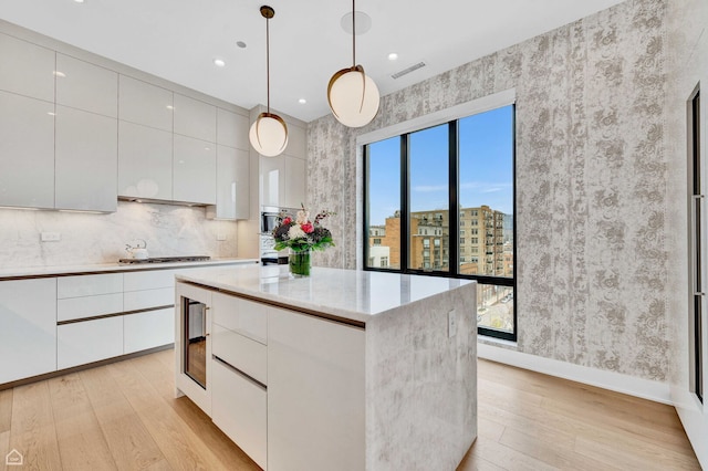 kitchen featuring light wood finished floors, wallpapered walls, modern cabinets, and white cabinetry