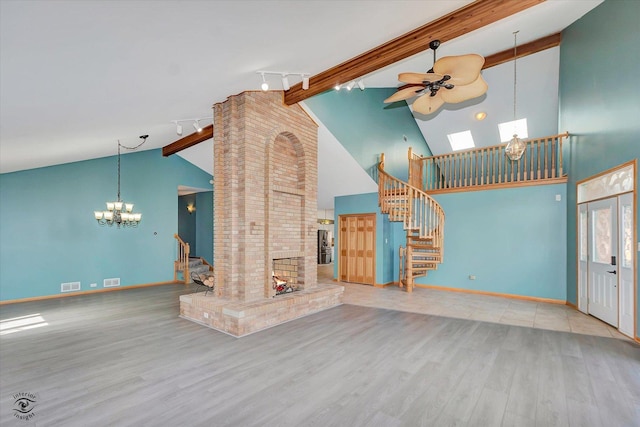 unfurnished living room featuring visible vents, beam ceiling, wood finished floors, baseboards, and stairs