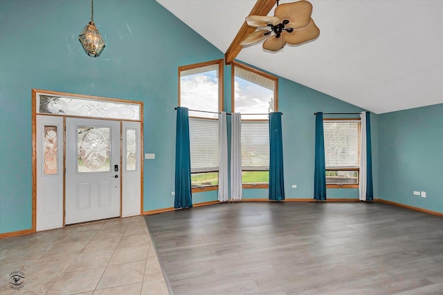 foyer with light wood-style floors, baseboards, ceiling fan, and high vaulted ceiling
