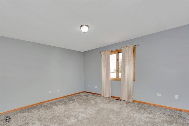 unfurnished room with baseboards and carpet floors