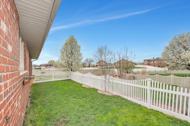 view of yard with a fenced backyard and a residential view