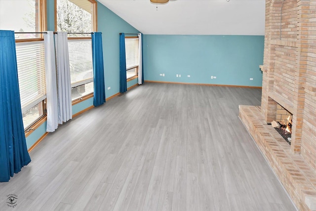 unfurnished living room featuring a fireplace, a ceiling fan, baseboards, wood finished floors, and vaulted ceiling