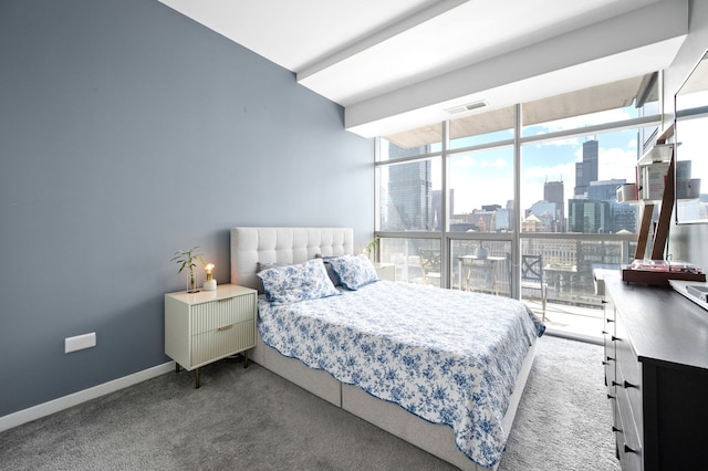 bedroom with visible vents, carpet floors, baseboards, floor to ceiling windows, and a city view