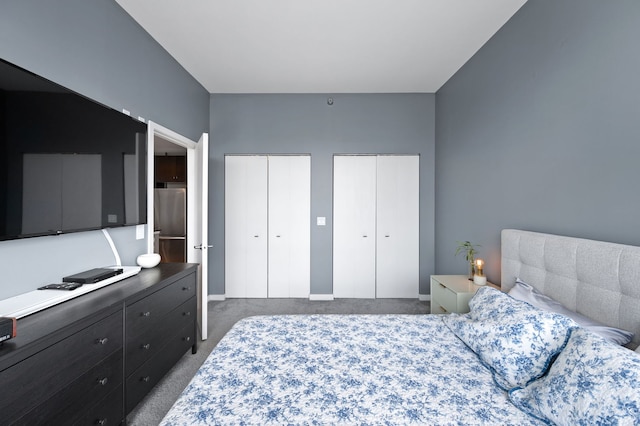 bedroom featuring carpet, multiple closets, and freestanding refrigerator