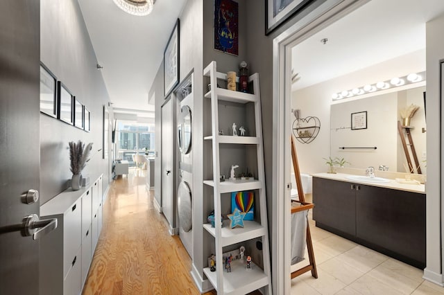 hall featuring a sink and light wood finished floors