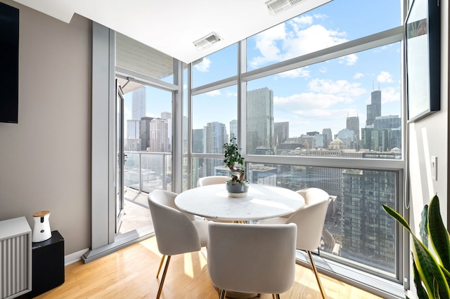 dining space featuring a city view, wood finished floors, and visible vents