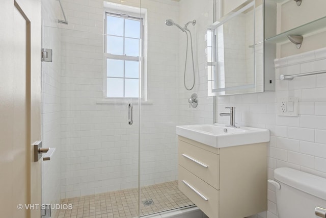 full bathroom with vanity, toilet, tile walls, and a stall shower