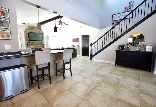 16725 92nd Ave, Orland Hills, IL 60487 - kitchen featuring ceiling fan, light tile patterned flooring, a breakfast bar area, beamed ceiling, and open floor plan