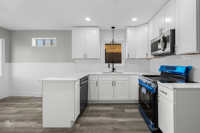 6330 W 64th Pl, Chicago, IL 60638 - kitchen featuring a wainscoted wall, stainless steel appliances, a sink, a peninsula, and white cabinetry