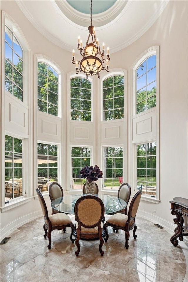 sunroom with a wealth of natural light, a notable chandelier, and visible vents