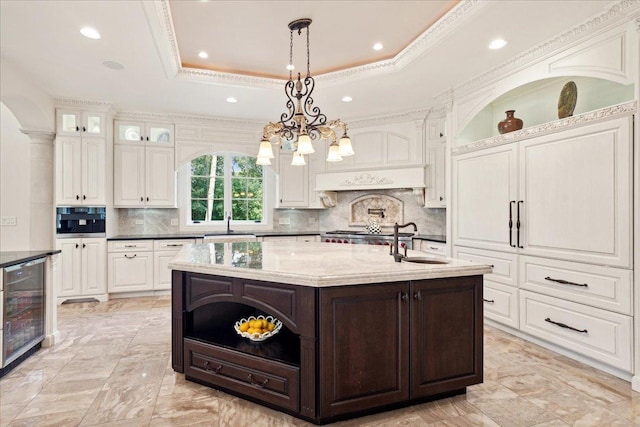 kitchen with open shelves, beverage cooler, dark brown cabinetry, and a sink