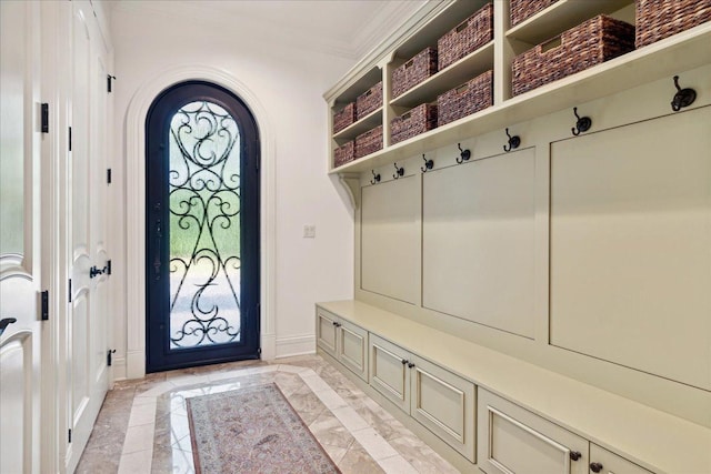 mudroom with arched walkways, baseboards, and ornamental molding