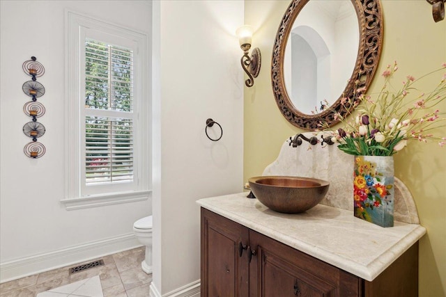 bathroom featuring tile patterned floors, toilet, visible vents, baseboards, and vanity
