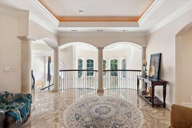 hallway featuring visible vents, ornate columns, a tray ceiling, and ornamental molding