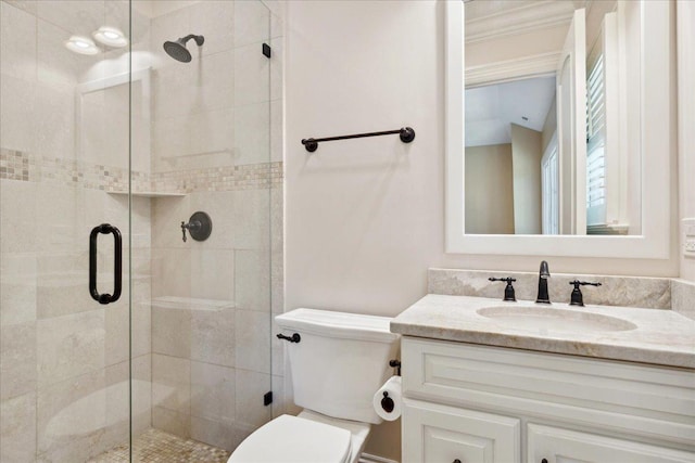 bathroom with a stall shower, vanity, and toilet
