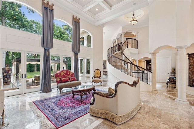 interior space with arched walkways, decorative columns, a towering ceiling, marble finish floor, and ornamental molding