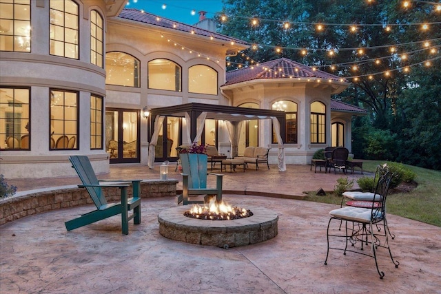 patio at twilight featuring an outdoor living space with a fire pit