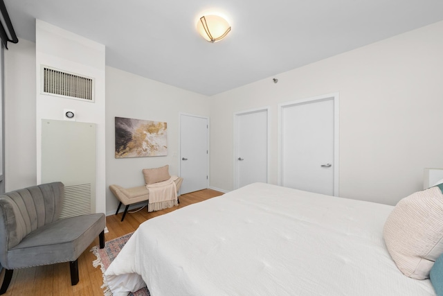 bedroom featuring wood finished floors and visible vents