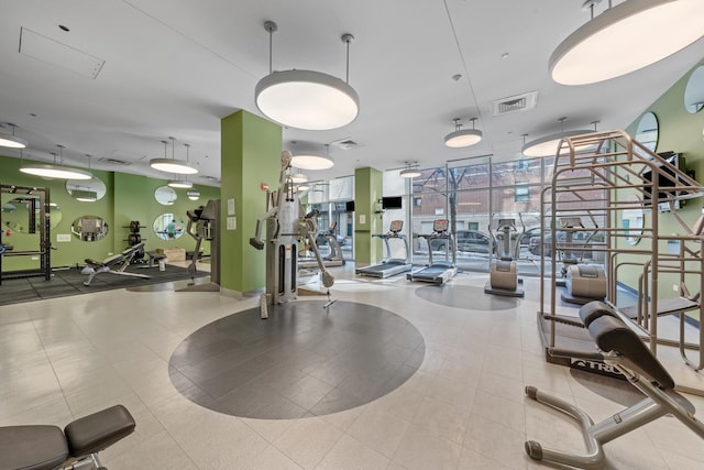 exercise room featuring expansive windows and visible vents