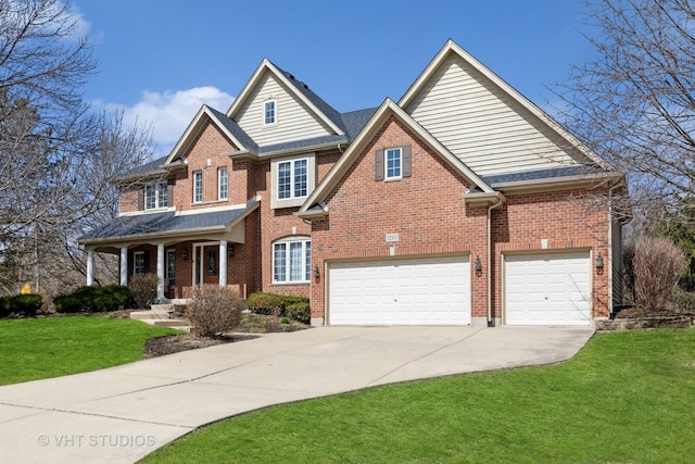 view of front of property with brick siding, covered porch, a garage, concrete driveway, and a front yard