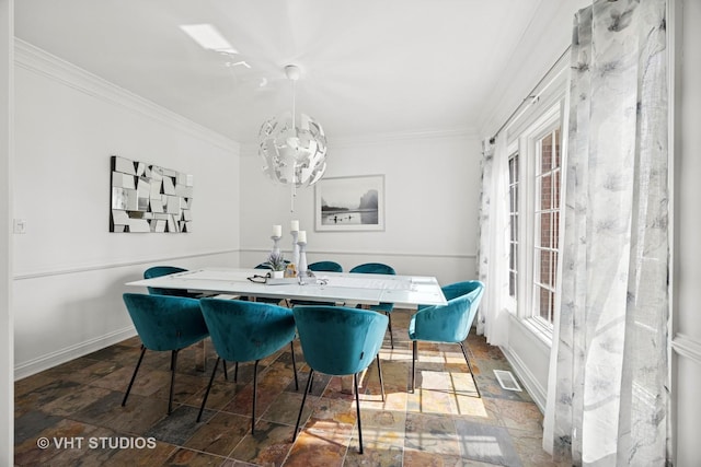 dining room with crown molding, visible vents, a chandelier, and stone tile floors